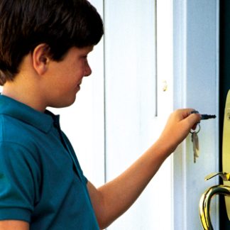 boy unlocking door to house